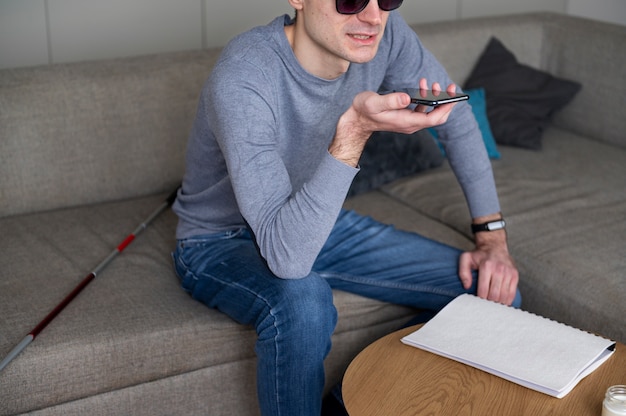 Foto grátis homem cego falando em seu smartphone