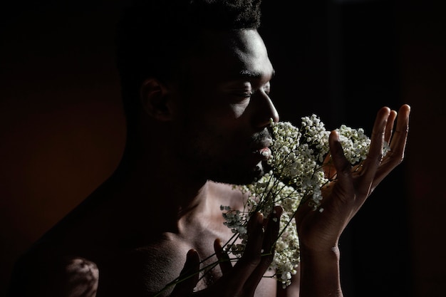 Foto grátis homem cheirando flores close-up