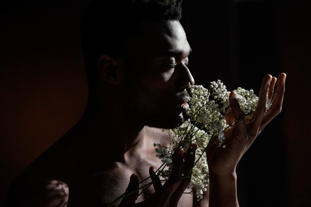 Homem cheirando flores close-up