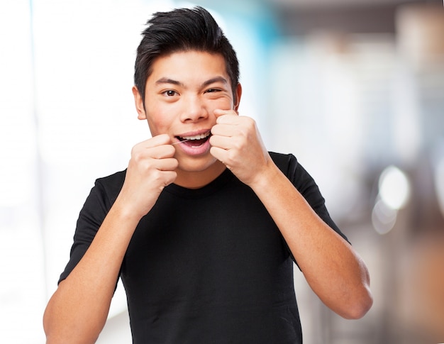 Homem chinês fresco usando flosh dental