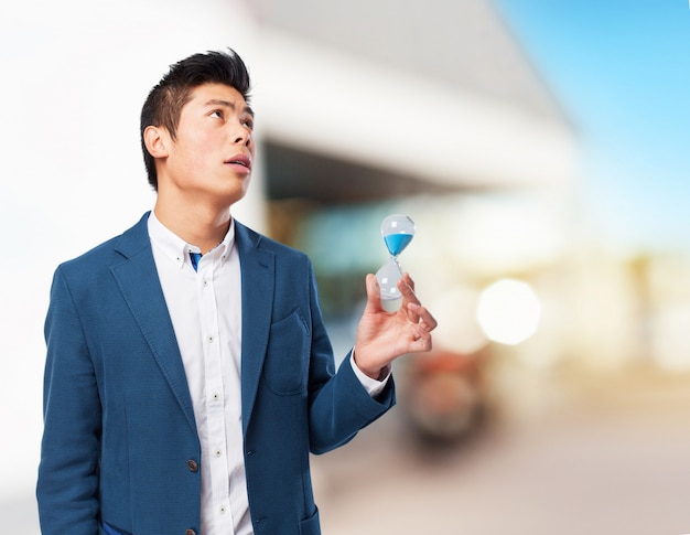 Homem chinês segurando areia-timer