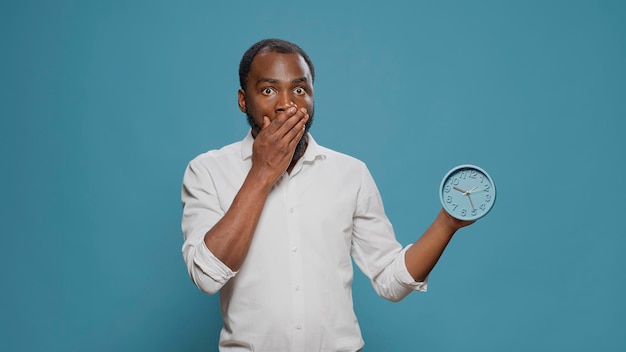 Homem chocado, verificando o tempo no relógio e atrasado para o trabalho, olhando para o relógio para ver horas e minutos. adulto impaciente desesperado se preocupando com o atraso no compromisso de trabalho. pontualidade