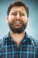 Foto grátis homem chorando de camisa azul