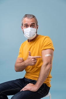 Homem com adesivo no braço após tomar vacina