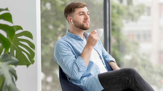 Foto grátis homem com airpods bebendo café