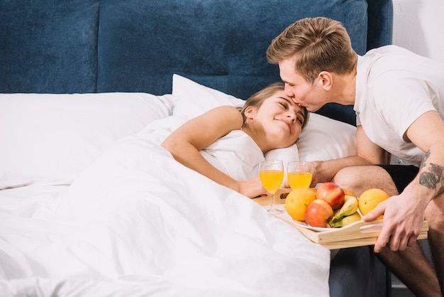 Homem, com, bandeja, de, alimento, beijando, mulher dormindo, ligado, testa