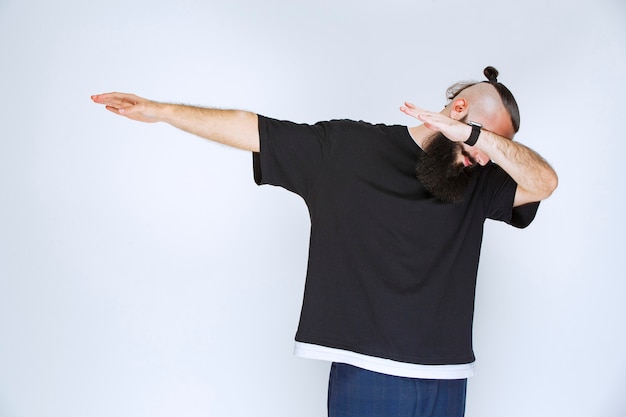 Homem com barba dançando ou fazendo poses extraordinárias.