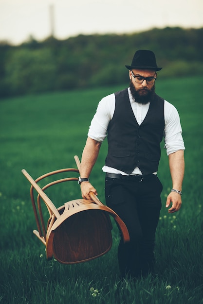 Homem com barba e óculos escuros no campo verde