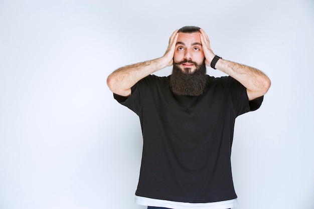 Homem com barba fica extremamente feliz por causa de alguma coisa.