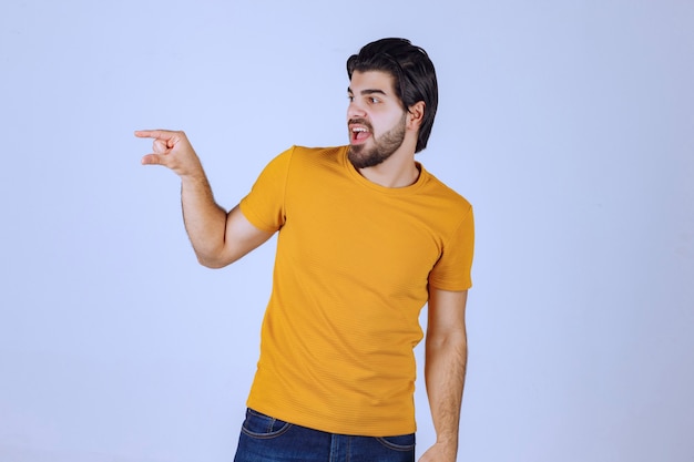 Homem com barba mostrando medidas estimadas de um objeto
