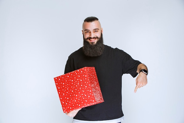 Homem com barba oferecendo caixa de presente vermelha