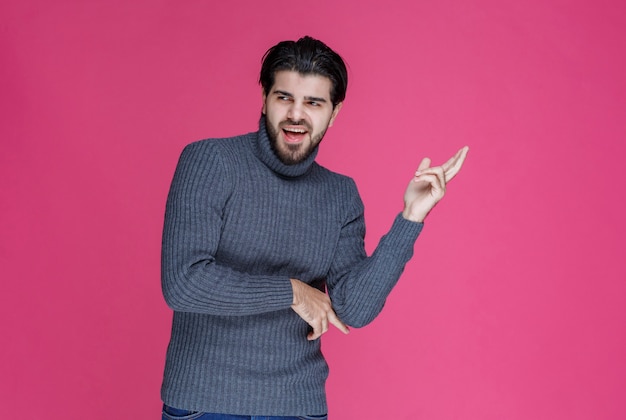 Homem com barba preta parece poderoso e autoconfiante.