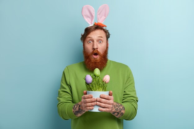 Homem com barba ruiva, roupas coloridas e orelhas de coelho