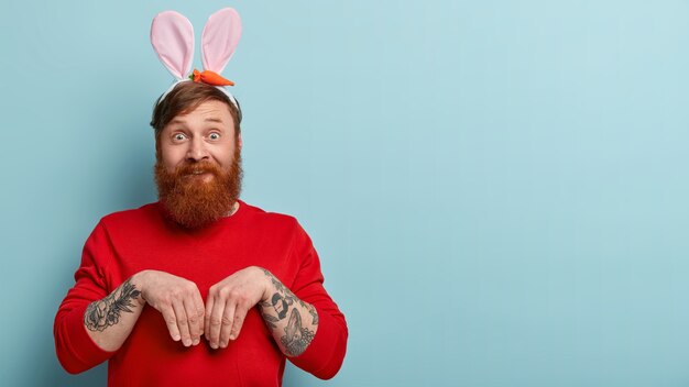 Homem com barba ruiva, roupas coloridas e orelhas de coelho