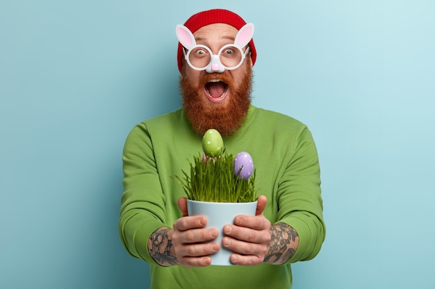 Foto grátis homem com barba ruiva usando roupas coloridas e óculos com orelhas de coelho