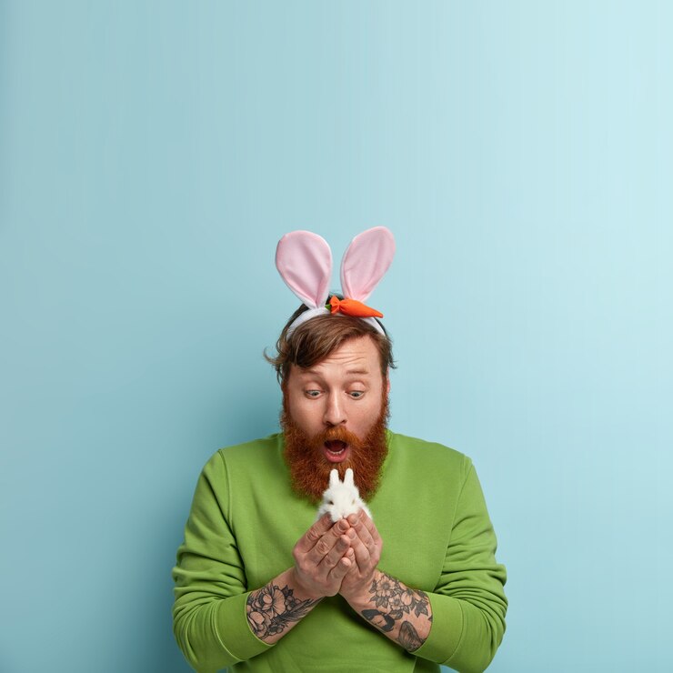 Foto grátis homem com barba ruiva, vestindo roupas coloridas e segurando um coelho