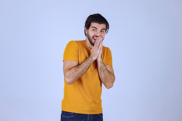 Foto grátis homem com barba unindo as mãos e rezando e pedindo algo