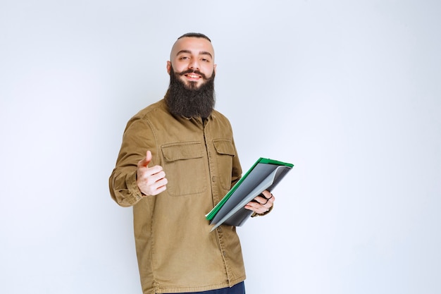 Homem com barba verificando a lista de projetos e parece satisfeito.