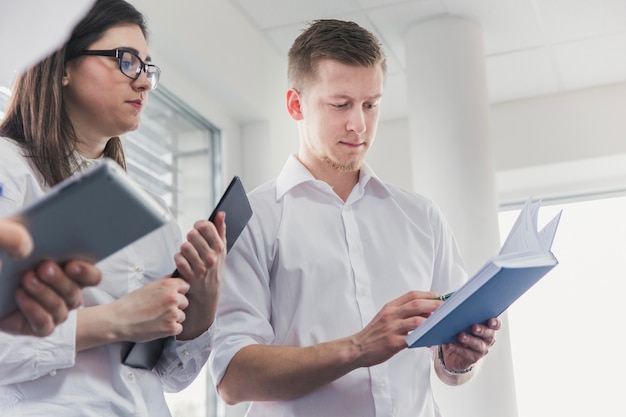 Homem com caderno na frente de colegas de trabalho