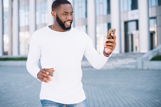 Foto grátis homem com café usando smartphone