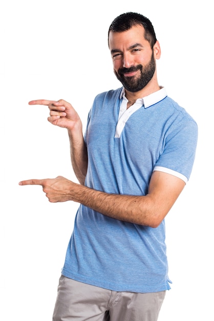 Homem com camisa azul apontando para o lateral