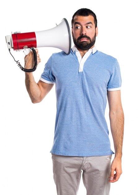 Homem com camisa azul gritando por megafone