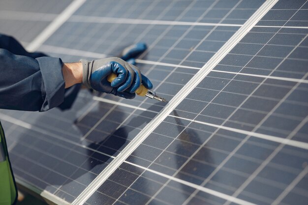 Homem com capacete branco perto de um painel solar