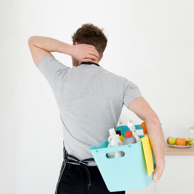 Homem com cesta de produtos de limpeza