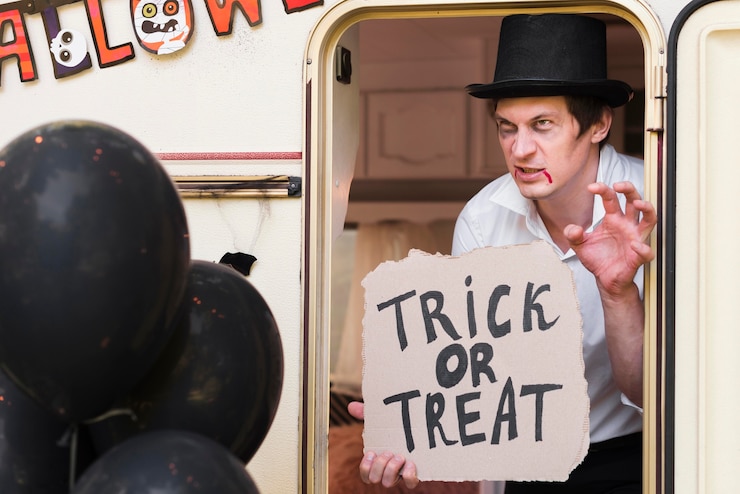 Foto grátis homem com chapéu segurando uma placa de doces ou travessuras