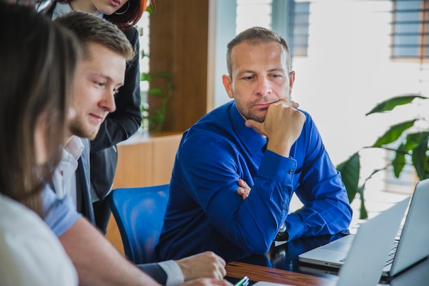 Foto grátis homem com colegas de trabalho pensando