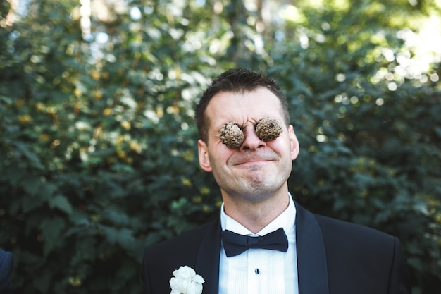 Foto grátis homem com cones de pinheiro nos olhos