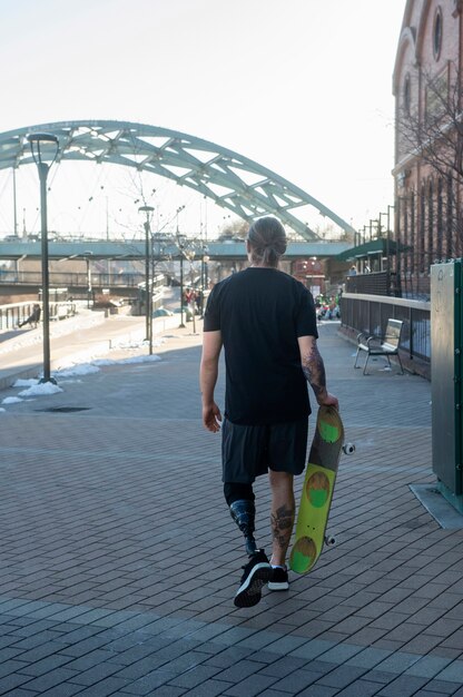 Homem com deficiência de perna andando de skate na cidade