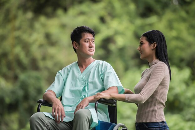 Homem com deficiência em cadeira de rodas e namorada no parque