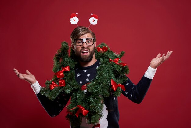 Homem com embaraçosa guirlanda de Natal