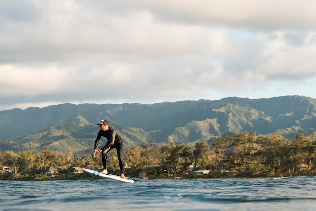 Homem com equipamento especial surfando no Havaí