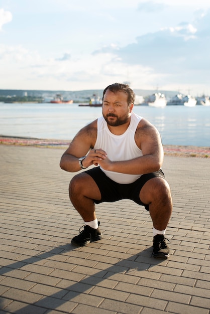 Foto grátis homem com excesso de peso se exercitando ao ar livre