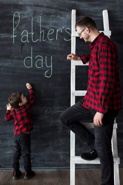 Homem, com, filho, ligado, dia pais, frente, chalkboard
