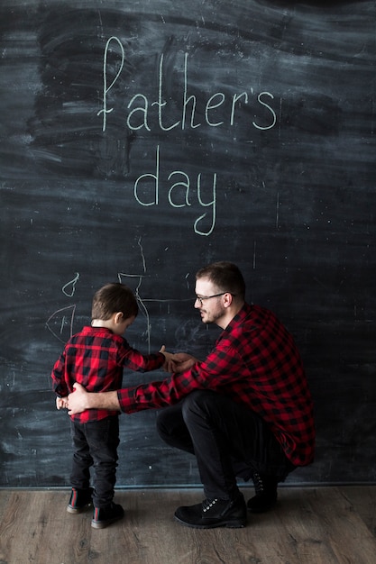 Homem, com, filho, ligado, dia pais, frente, chalkboard