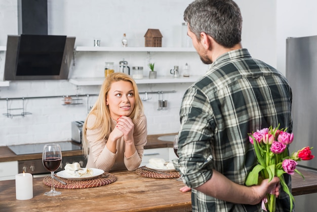 Homem, com, flores, de, costas, e, mulher, em, cozinha