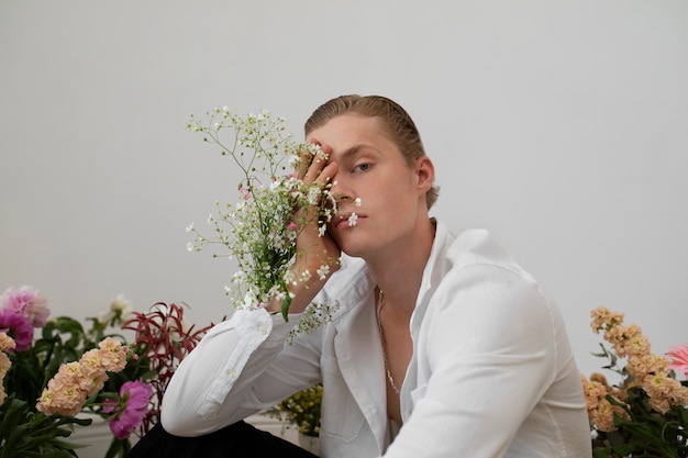 Foto grátis homem com flores posando vista lateral