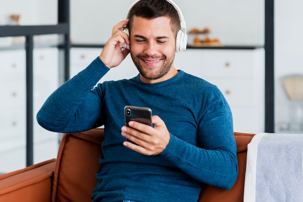 Homem com fone de ouvido e celular na mão