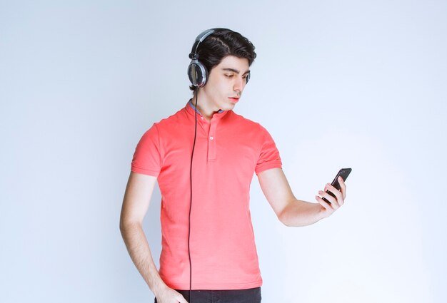 Homem com fones de ouvido, definindo música ou fazendo uma chamada online.