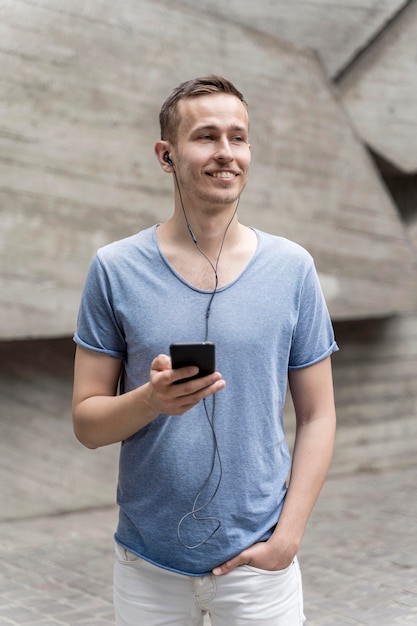 Foto grátis homem com fones de ouvido e celular