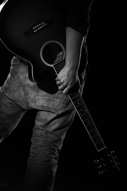 Homem com guitarra na escuridão