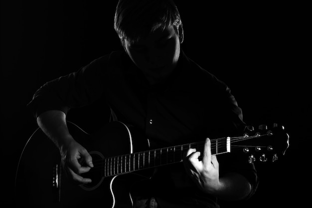 Homem com guitarra na escuridão