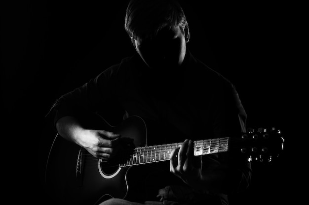 Homem com guitarra na escuridão