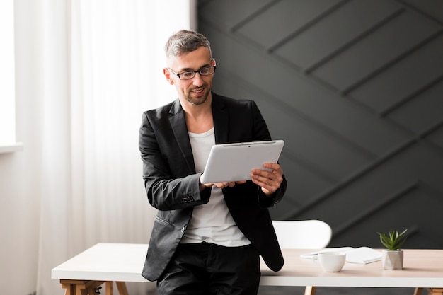 Homem com jaqueta preta, olhando para tablet