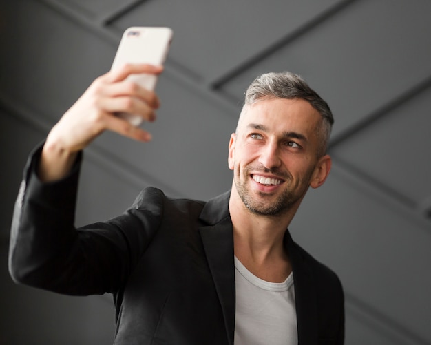 Foto grátis homem com jaqueta preta tomando uma selfie