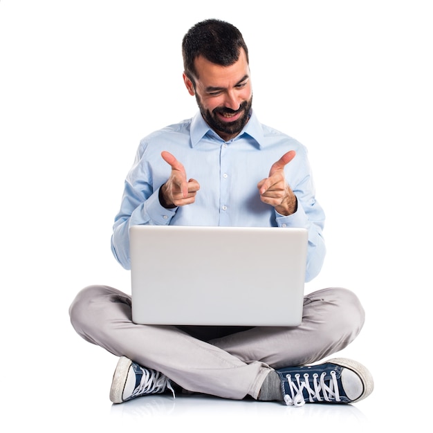 Foto grátis homem com laptop apontando para a frente