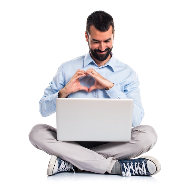 Foto grátis homem com laptop fazendo um coração com as mãos